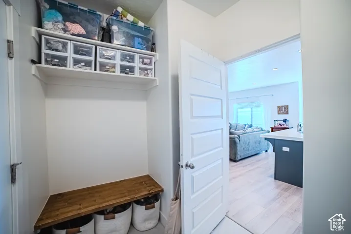 Built-in corner bench with wood finish, multiple wall-mounted shelves, and a paneled interior door