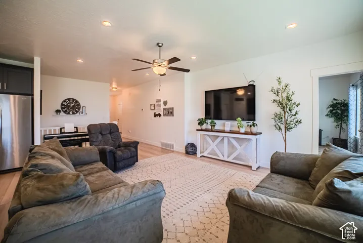 Recessed lighting throughout, ceiling fan with light fixture, wood-finish flooring, and white trim