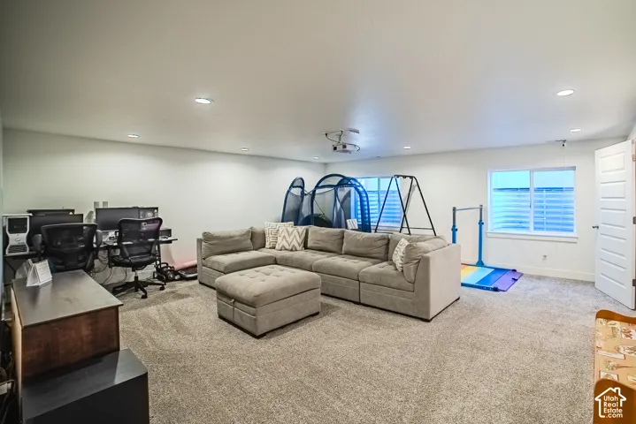 Recessed lighting illuminates the carpeted flooring and white walls