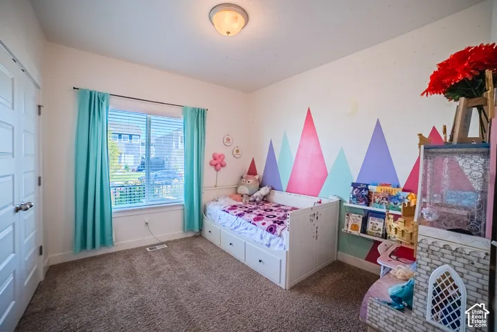 Carpeted flooring, window with blinds, panel closet door, flush mount ceiling light, and built-in shelving