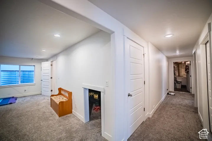 Carpeted flooring throughout, recessed ceiling lighting, multi-pane windows, white interior doors, and white trim