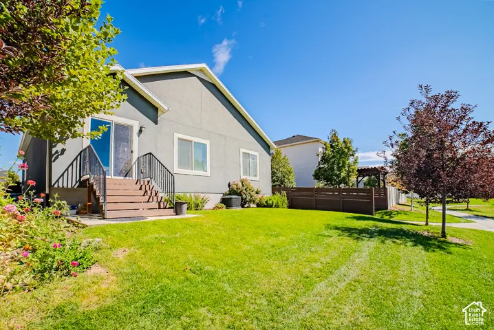 Rear exterior with a wood-finish deck and black metal railings, leading to a sliding glass door