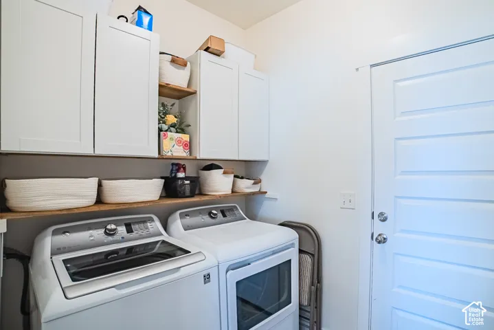 White shaker-style cabinetry with integrated wood shelving, and a paneled door with chrome hardware