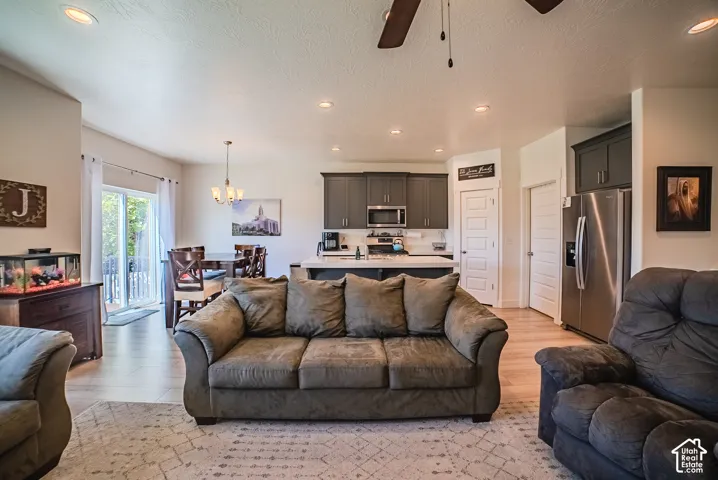 Open-concept living space featuring wood-finish flooring, recessed lighting, and a ceiling fan
