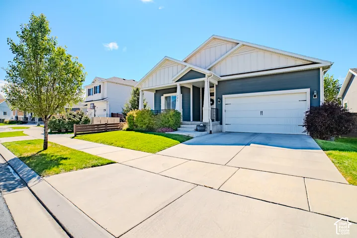 Exterior featuring a two-car garage, covered entry, and a concrete driveway