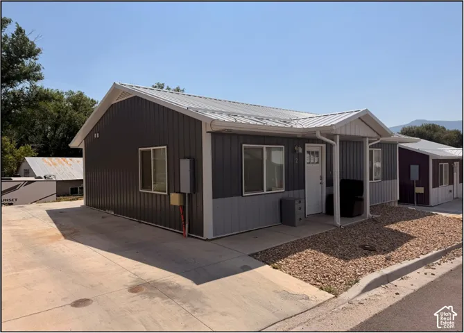 Metal siding exterior with a pitched metal roof, covered entry, and gravel landscaping