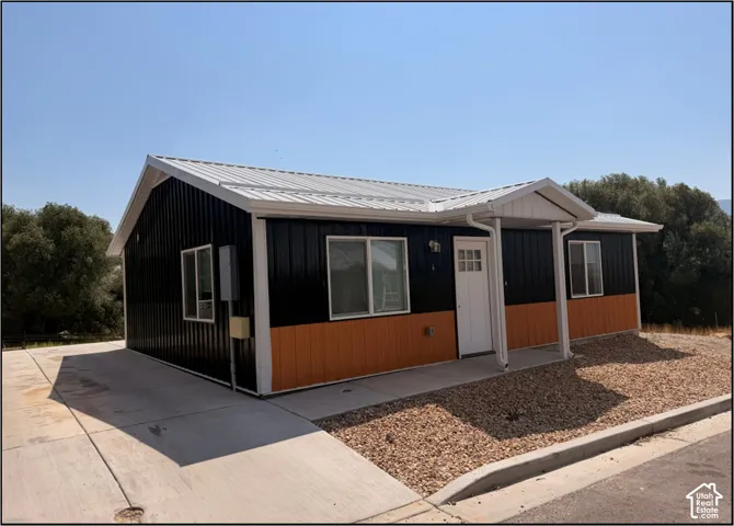 Contemporary exterior with black vertical siding and a white metal roof