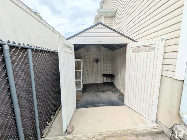 Detached storage shed with a peaked roof, double-door entry, and integrated shelving