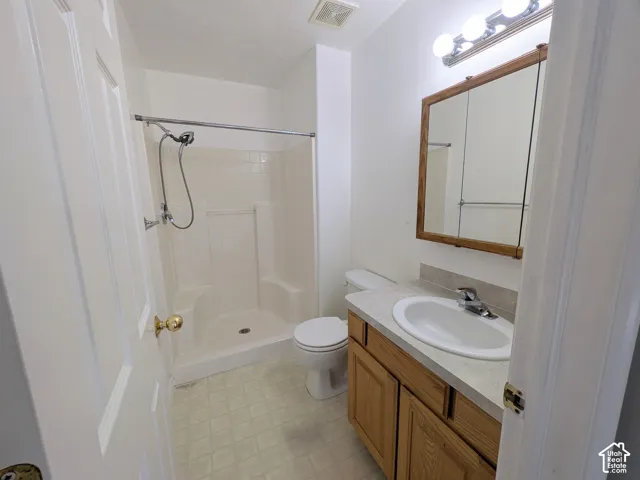 Bathroom featuring a single vanity with wood-finish cabinetry, a built-in sink, and a framed mirrored medicine cabinet