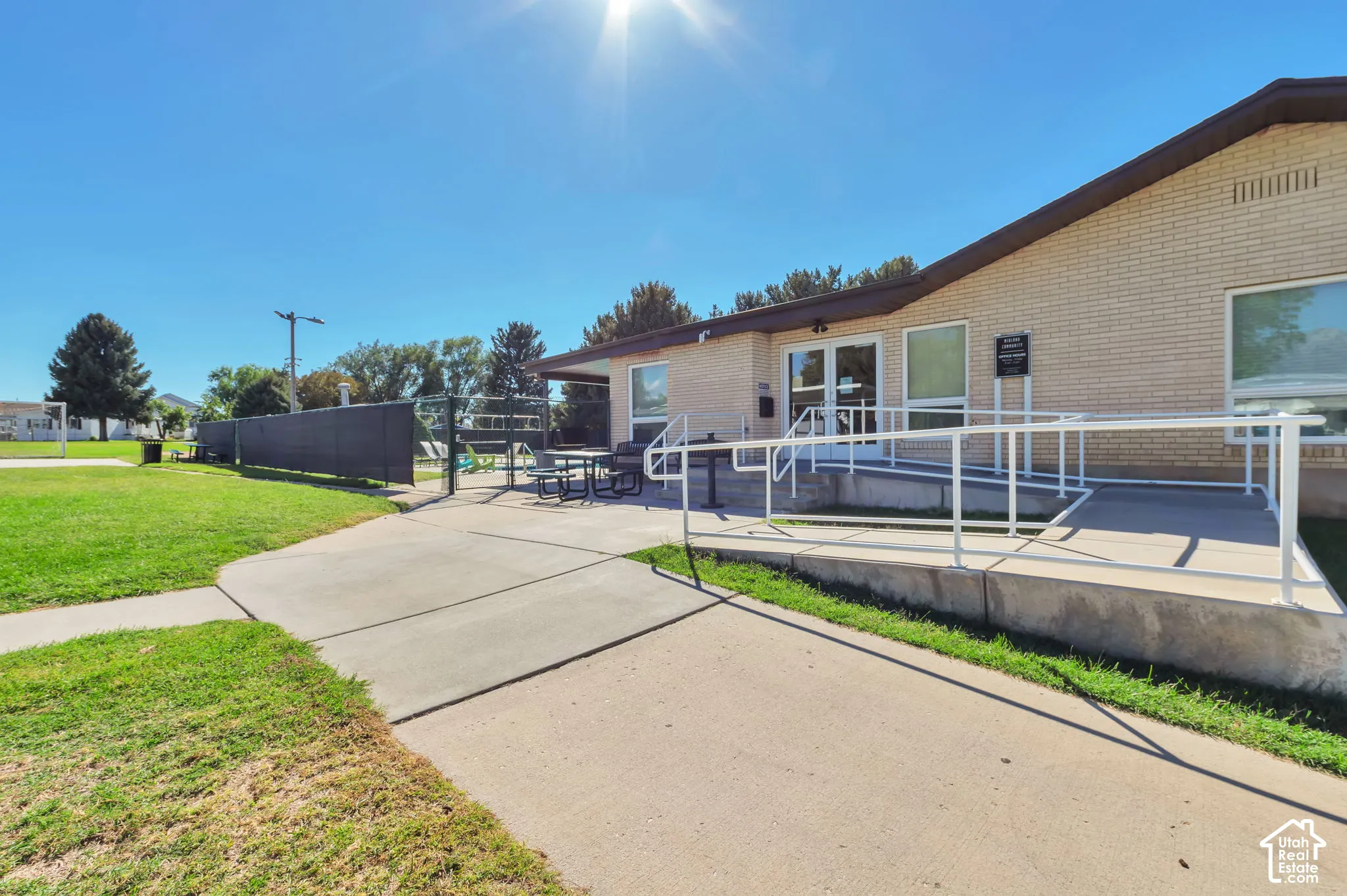 Brick exterior with a covered entry, concrete walkway, and a white handrail