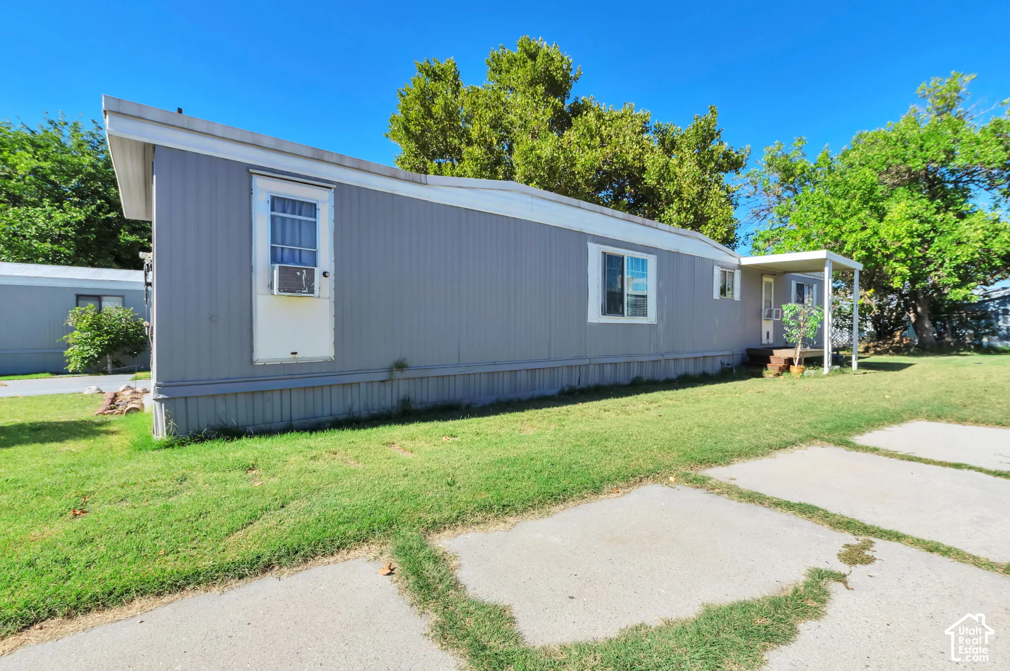 Gray exterior siding with white trim, multiple windows, and a covered porch