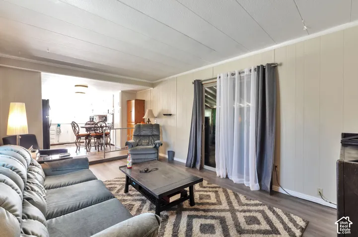 Wood-finish flooring throughout, vertical plank wall paneling, and a white plank ceiling
