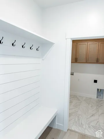 Built-in mudroom bench with shiplap backing and coat hooks