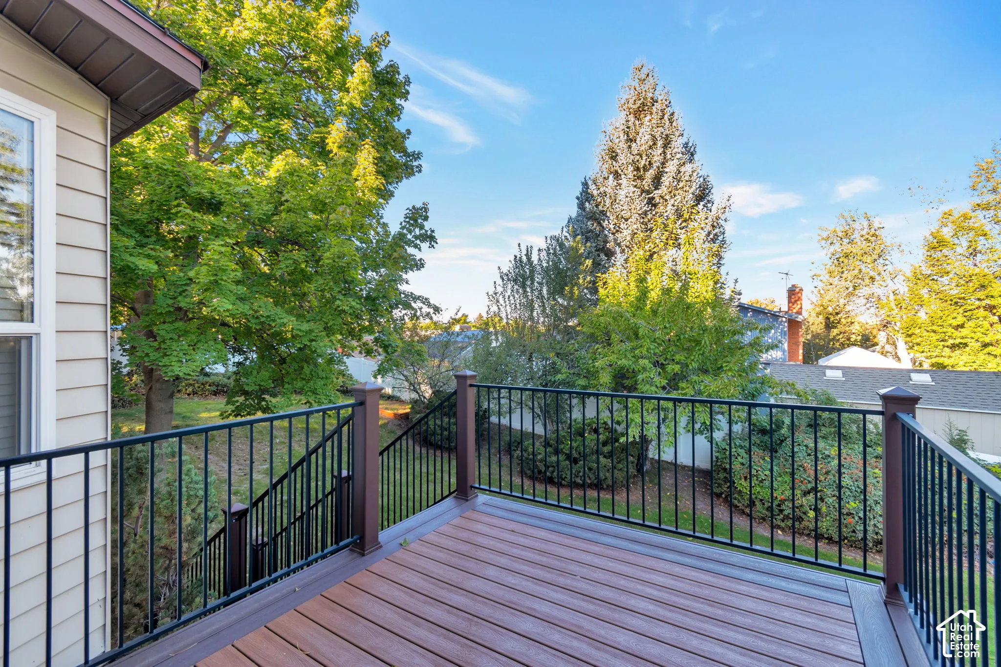 Spacious outdoor deck with composite decking and black metal railings