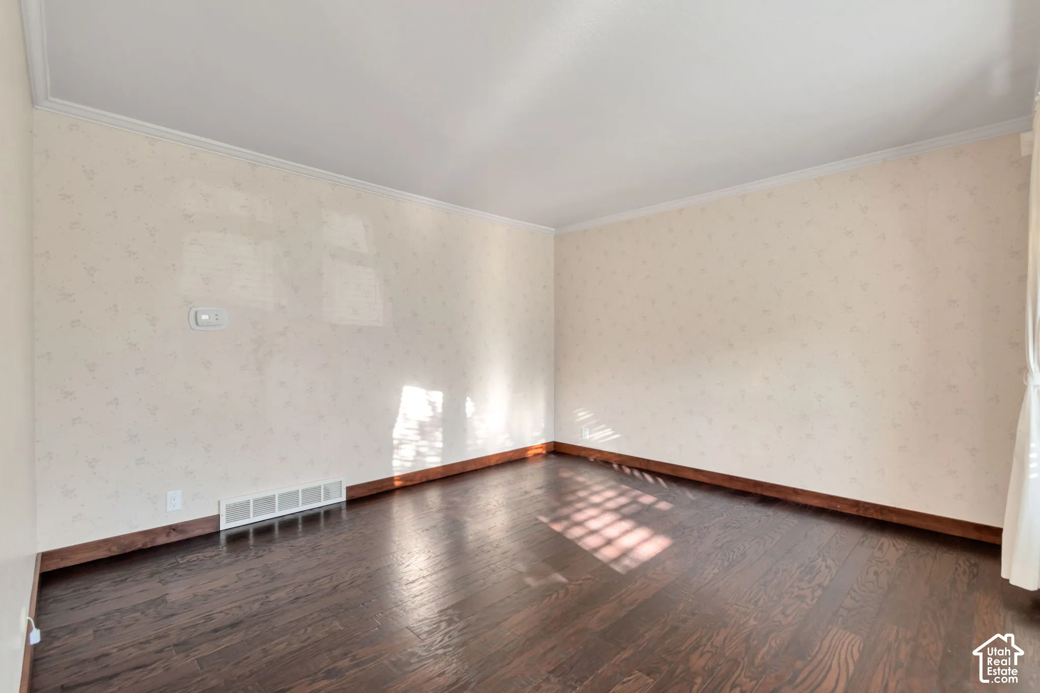 Hardwood-finish flooring, patterned wallpaper, crown molding, and white window blinds