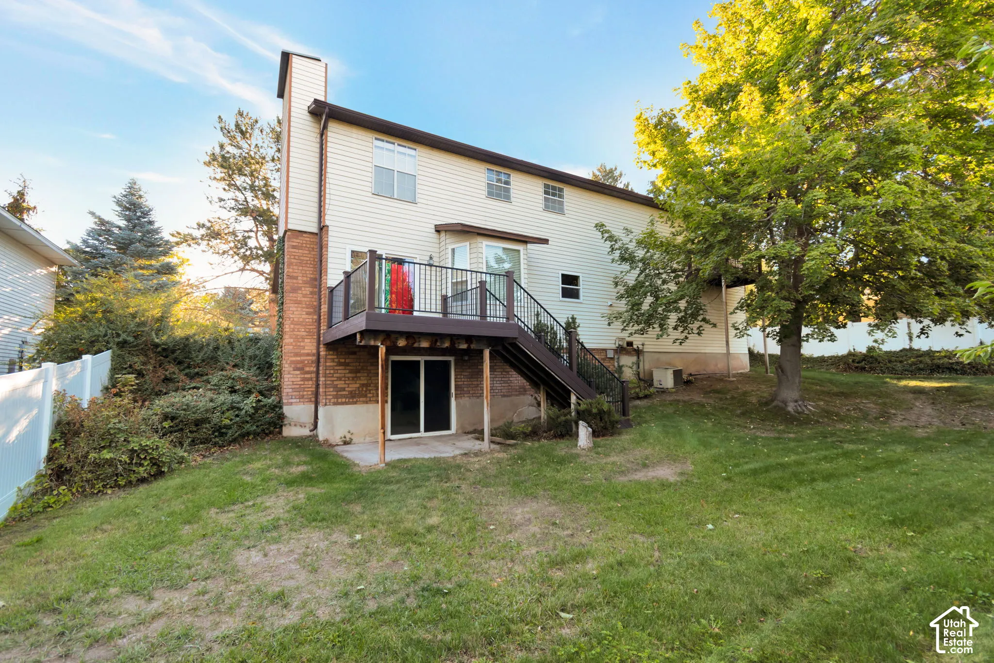 Expansive backyard featuring a multi-level deck, a sliding glass door to the lower level, and mature trees