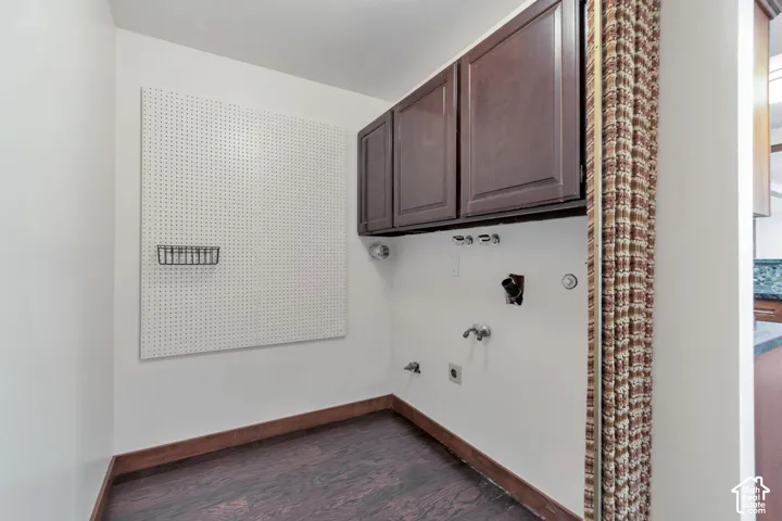 Built-in cabinetry, wood-finish flooring, and a pegboard wall