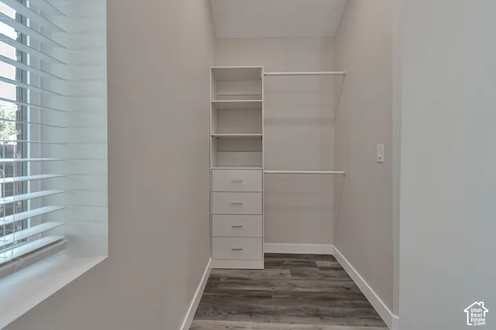 Built-in walk in closet with closet system featuring shelving, drawers, and hanging rods