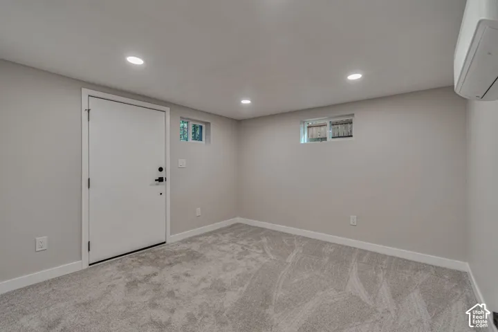 Recessed lighting, light gray wall finish, light gray carpet flooring, white trim, and a white interior door