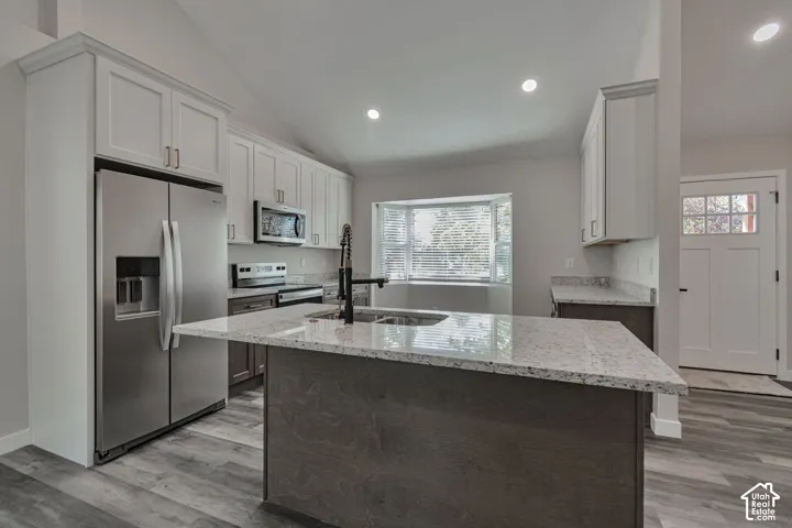 Kitchen featuring white upper cabinetry, dark wood-finish lower cabinetry, and light-toned granite countertops