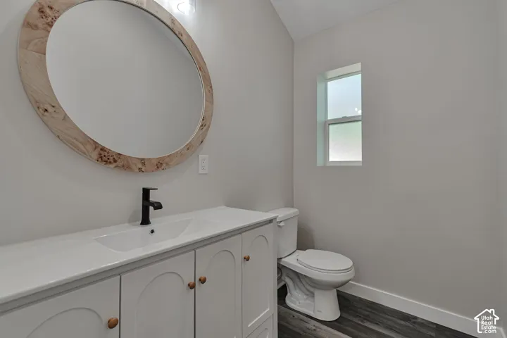 White vanity with shaker-style cabinetry, a matte black faucet, and a porcelain countertop with an integrated rectangular sink