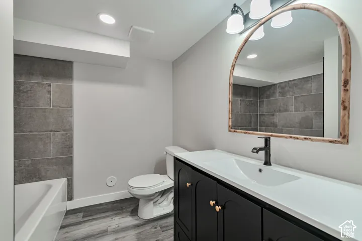 Contemporary vanity with a white countertop and integrated sink, matte black faucet, and arched mirror