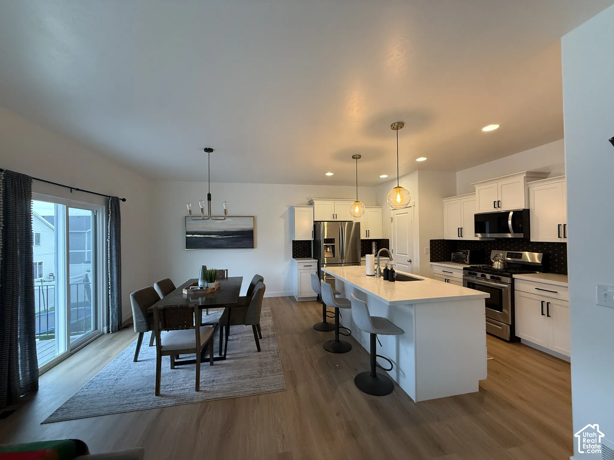 Open-concept kitchen and dining area featuring wood-finish flooring