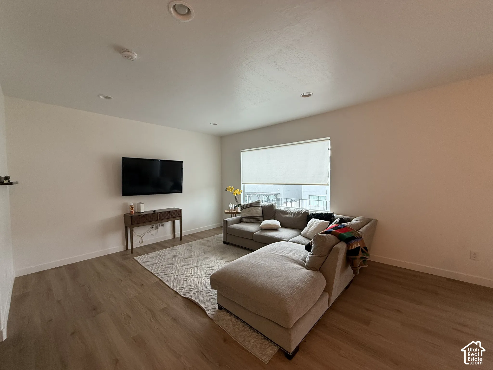 Recessed lighting, wood-finish flooring, and white walls
