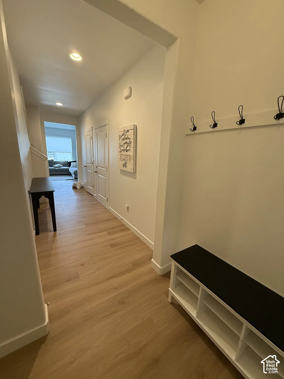 Recessed ceiling lighting, wood-finish flooring, and white walls