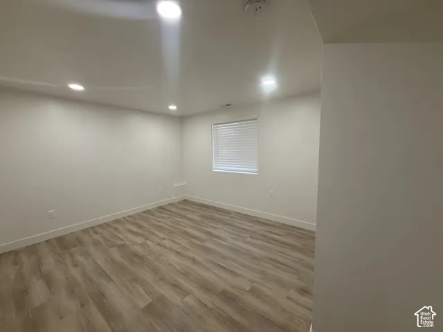 Wood-finish flooring, recessed lighting, and a window with horizontal blinds