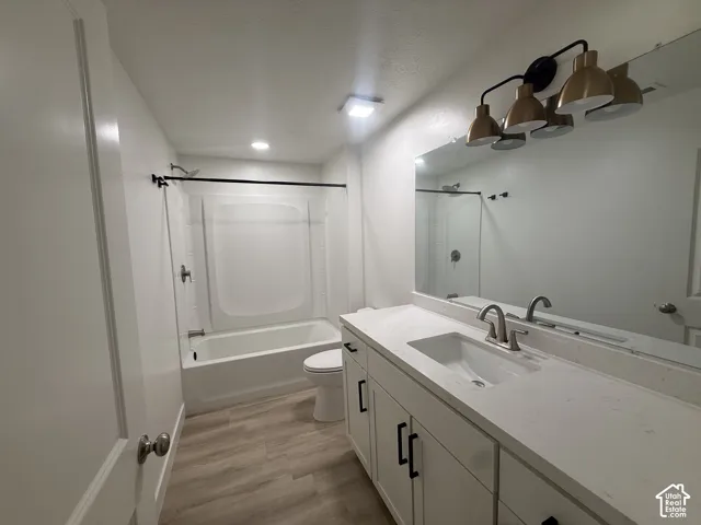 White vanity with a single basin sink, white countertop, and brushed nickel faucet