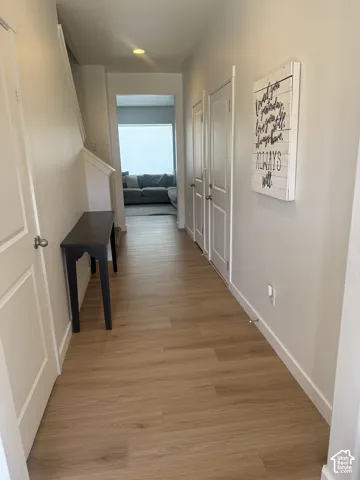 Entryway featuring wood-finish flooring, white paneled doors, and recessed lighting