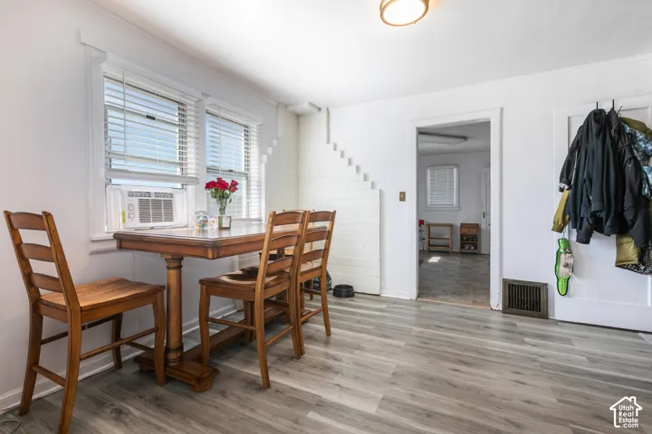 Wood-finish flooring with white trim, a double window, and recessed lighting