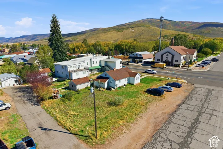 Mountain backdrop, residential structures, commercial structures, paved road access, multiple parking spaces