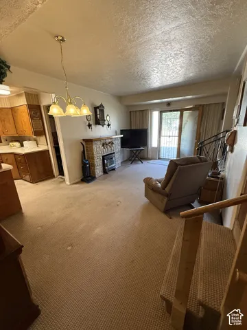 Spacious living area featuring a stone fireplace, direct outdoor access, and a built-in staircase