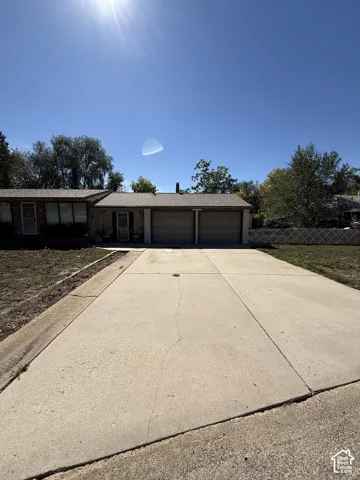 Spacious driveway with concrete surface leading to a two-car garage