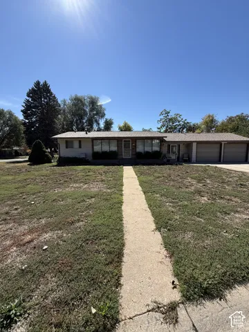 Ranch-style residence featuring a brick facade, multiple large windows, and an attached two-car garage