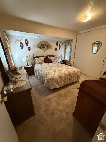 Carpeted flooring, recessed lighting, and a window with drapery