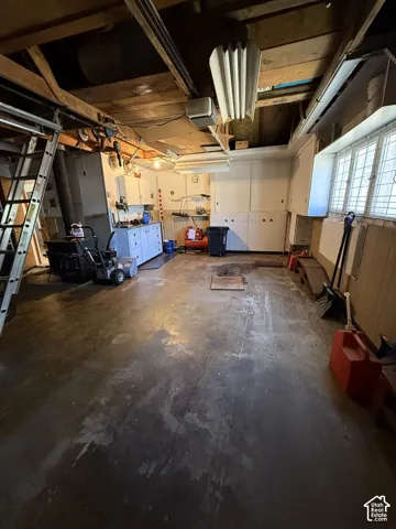 Spacious utility area featuring exposed ceiling beams, built-in cabinetry, and multi-pane windows