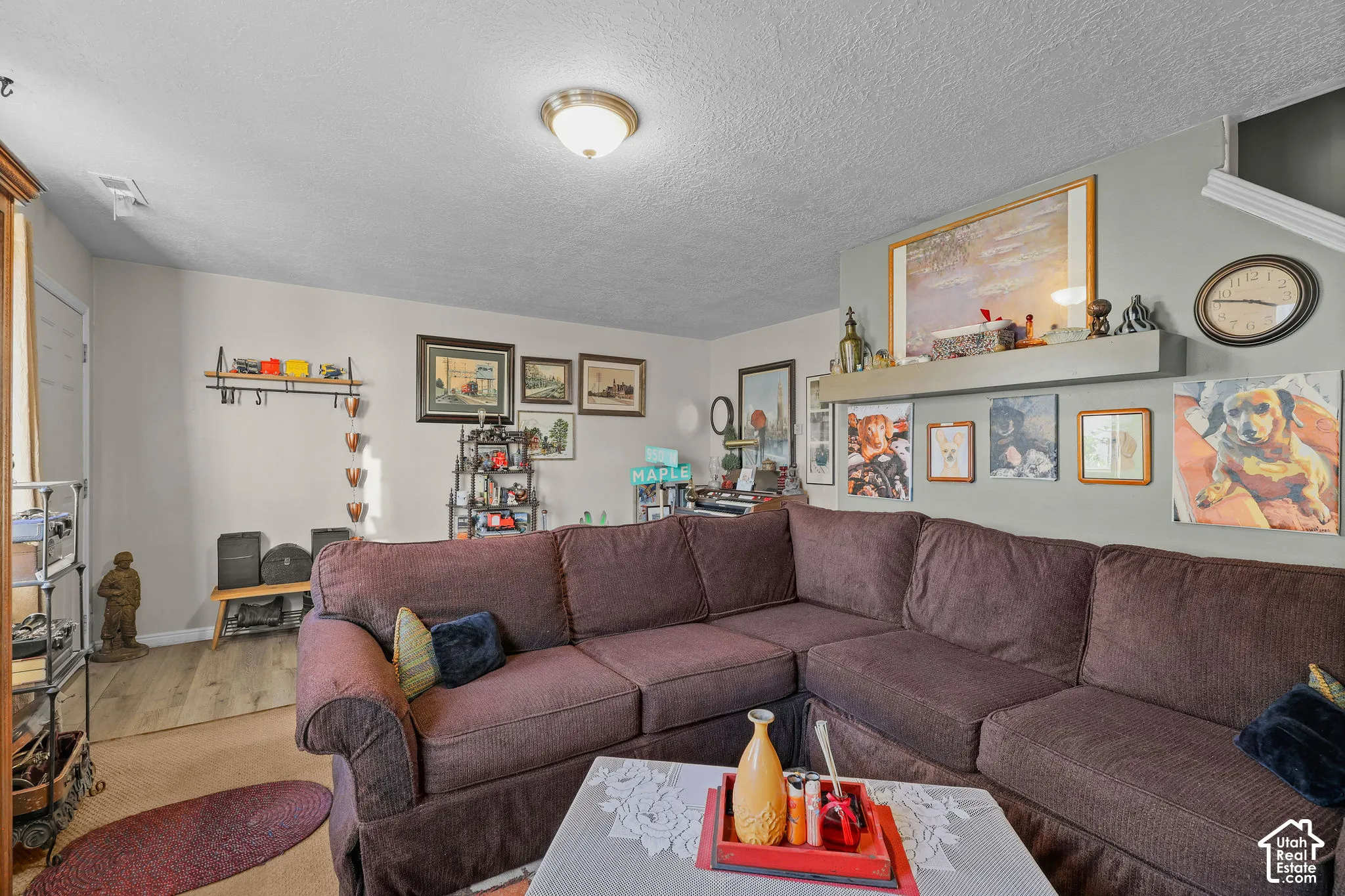 Unit B, Neutral wall paint, ceiling-mounted light fixture, L-shaped furniture arrangement