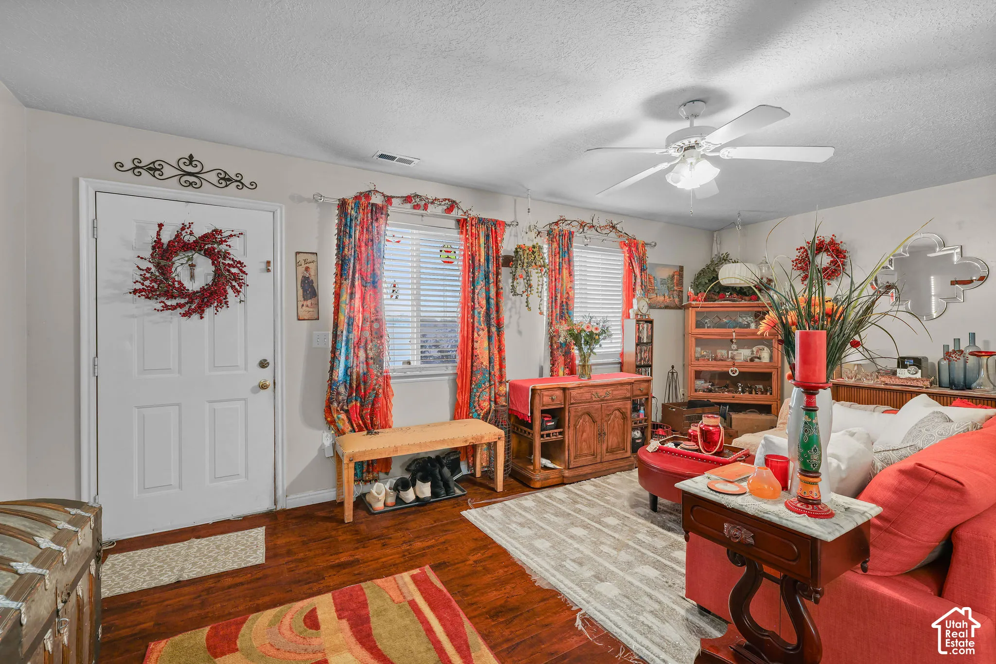 Unit A, Wood-type flooring with a white entry door, multiple windows, and a ceiling fan with integrated lighting