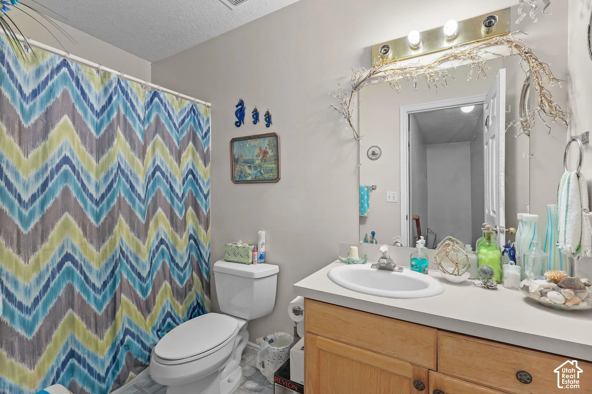 Unit A, Vanity with integrated sink, wood-finish cabinetry, and overhead lighting fixture