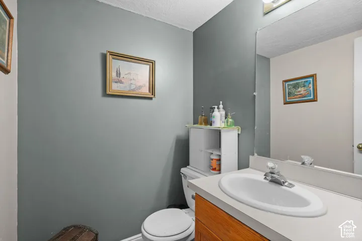 Unit B, Vanity with an integrated oval sink and chrome faucet, wood-finish cabinetry, and a large wall-mounted mirror