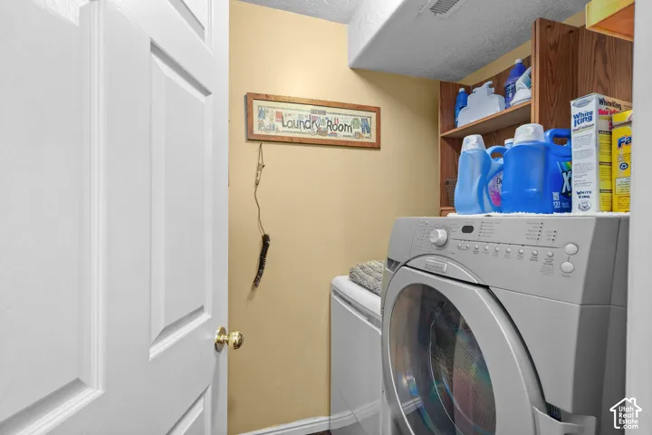 Unit B, Laundry area with built-in wood shelving, painted walls, and white paneled door