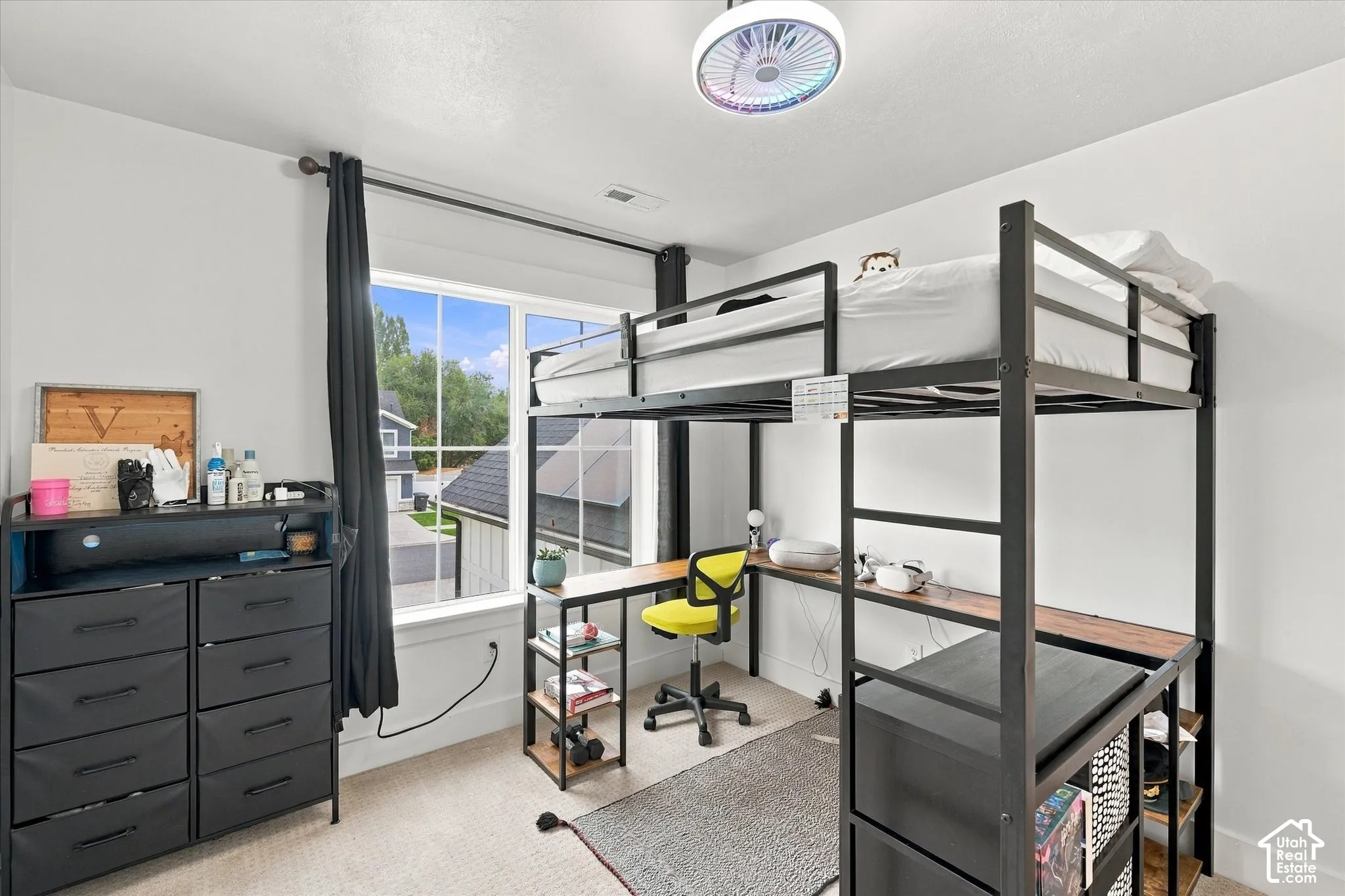 Loft bed system with integrated desk, white walls, and a large window