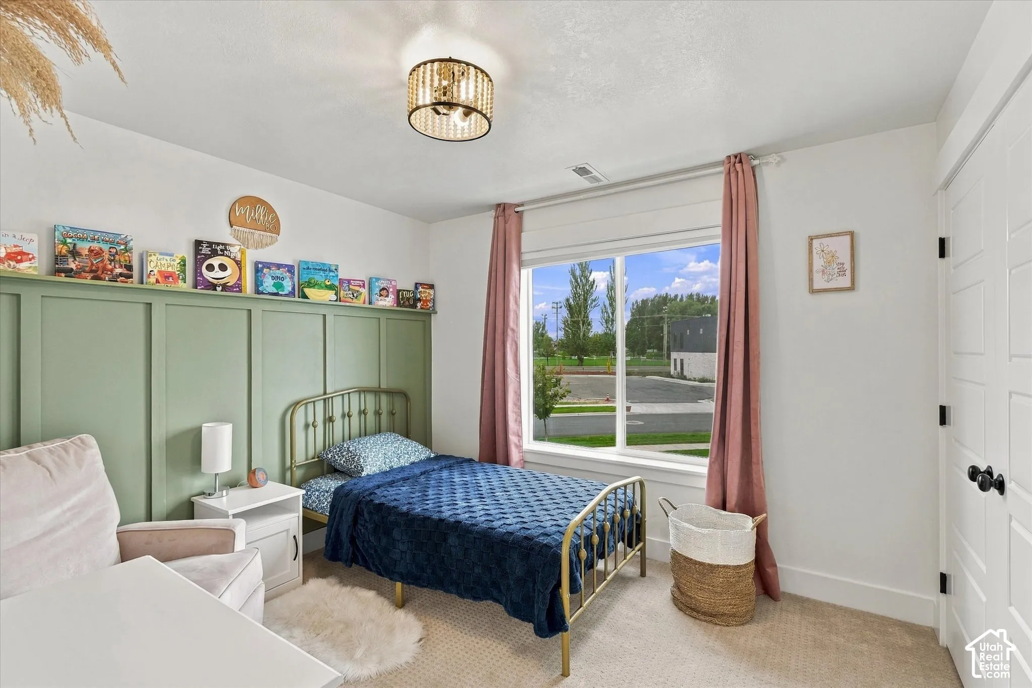 Room featuring a decorative wall paneling, a large window with white framing, a flush mount lighting fixture, and a paneled door with black hardware