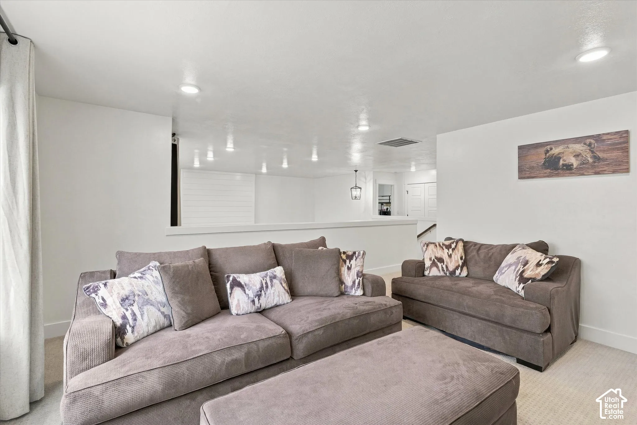 Recessed lighting, wall-to-wall carpeting, and a half-wall partition