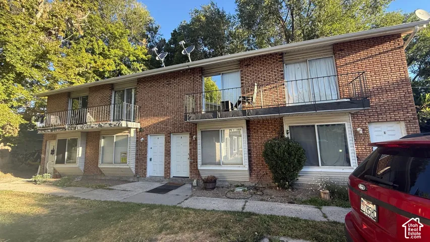 Brick exterior building with multiple balconies and ground-level entryways