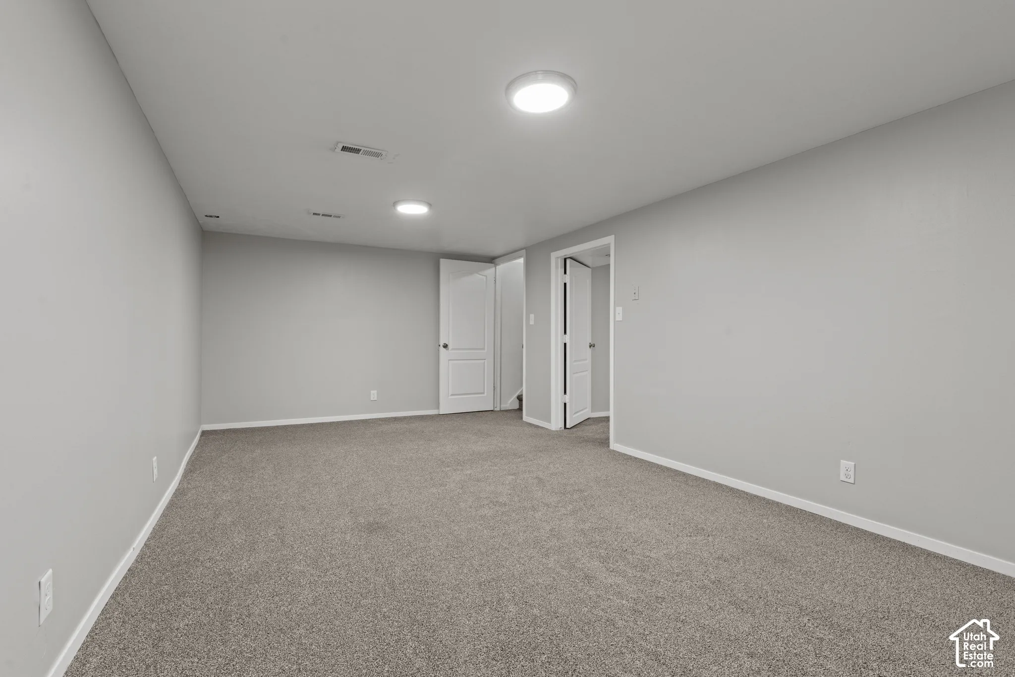 Carpeted room with light gray walls, white trim, and recessed lighting