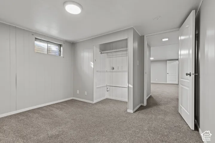 Carpeted flooring, recessed lighting, built-in closet storage, painted paneling, and white trim